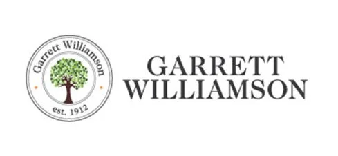 Logo of Garrett Williamson with a tree inside a circle and the text 'est. 1912'.