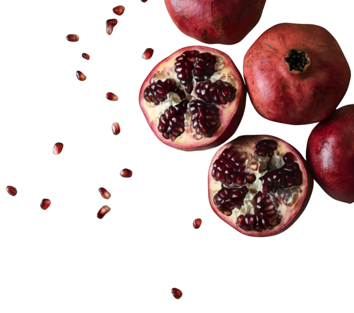 Three pomegranates, two whole and one cut open, revealing red seeds inside, with seeds scattered around.