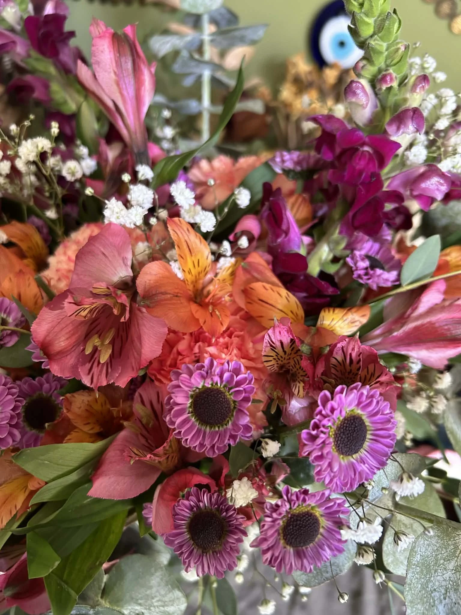 Close-up of a colorful bouquet of various flowers, including pink, orange, purple, and white blossoms.