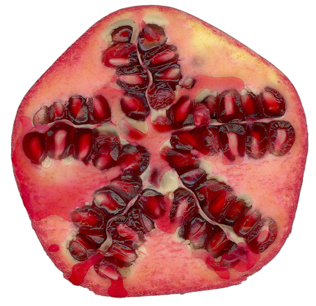 Cross-section of a pomegranate showing red seeds inside a pinkish outer skin.