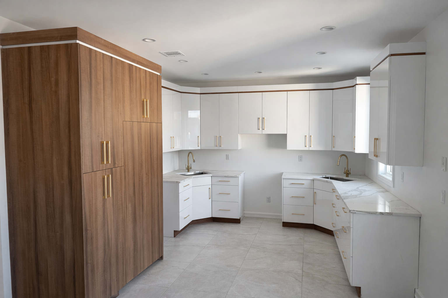 Modern kitchen with white cabinets, marble countertops, and gold hardware, featuring a large wooden pantry on the left and a window above the sink on the right.