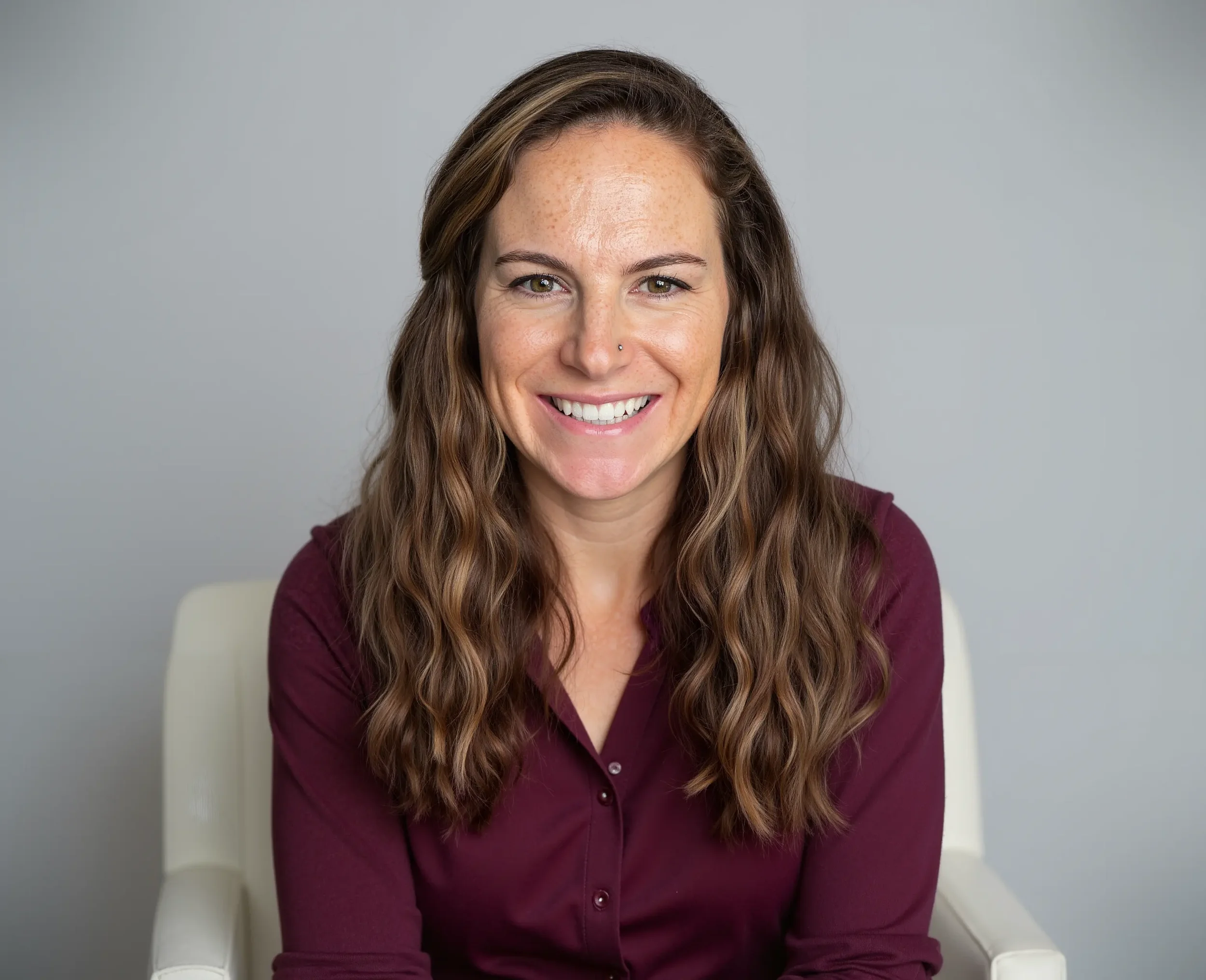 Professional headshot of Tiffany Callaway, LCSW, an Alaskan therapy telehealth provider, wearing a maroon shirt.
