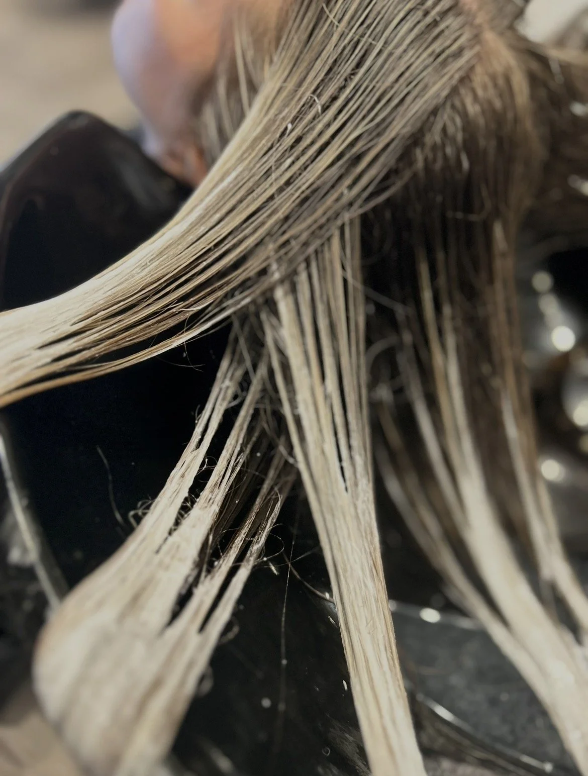 Close-up of blonde hair strands with a black background.