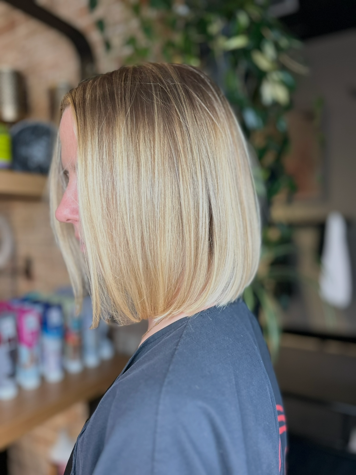 Side view of a woman with shoulder-length blonde hair in a salon.
