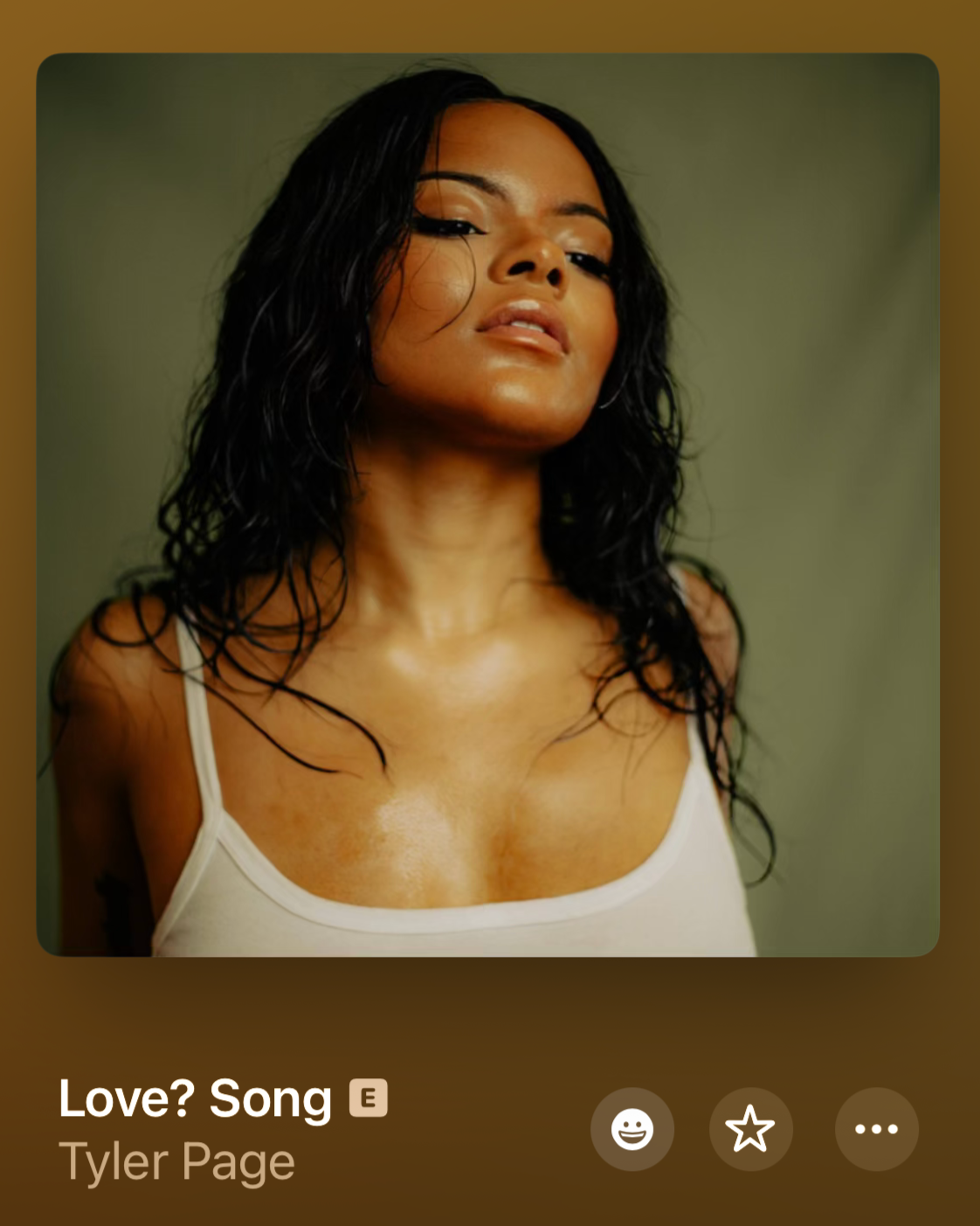 Close-up photo of a woman with curly black hair, wearing a white tank top, looking confidently at the camera with a slightly tilted head and a neutral expression.