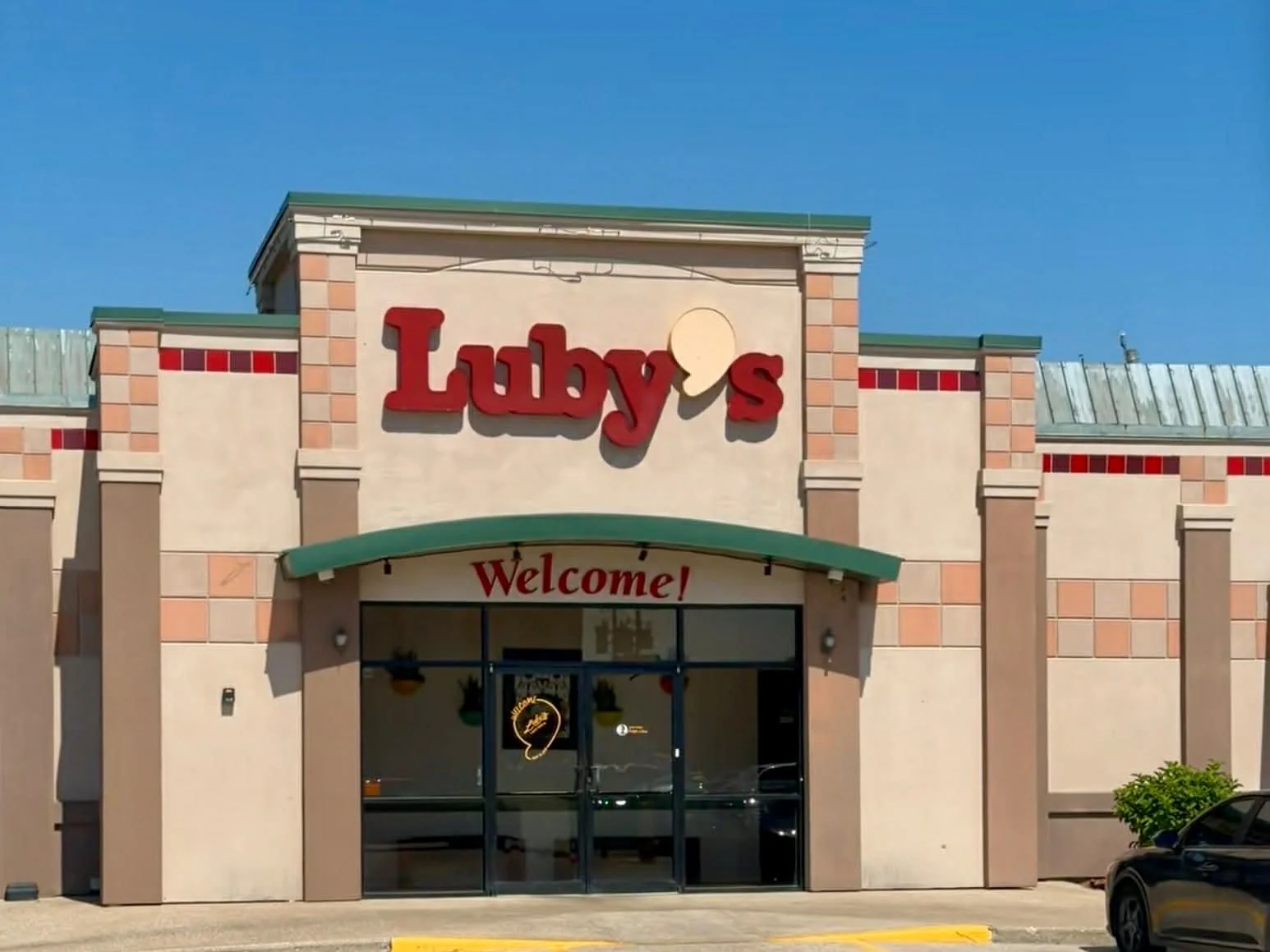 Exterior of a shopping center with a sign for Luby's and a welcoming entrance.