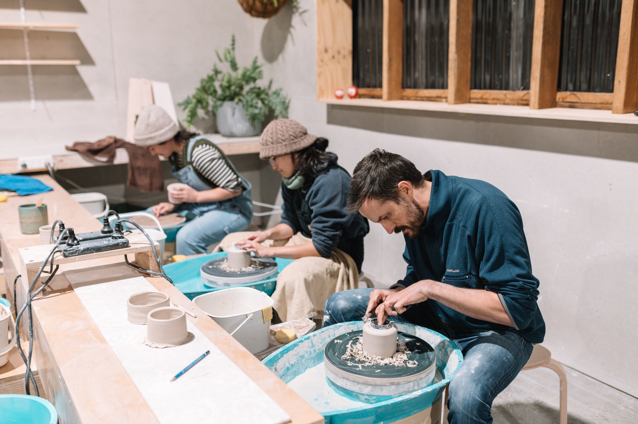 Students learning wheel throwing in a small group pottery class at Huon Valley Pottery near Hobart, Tasmania