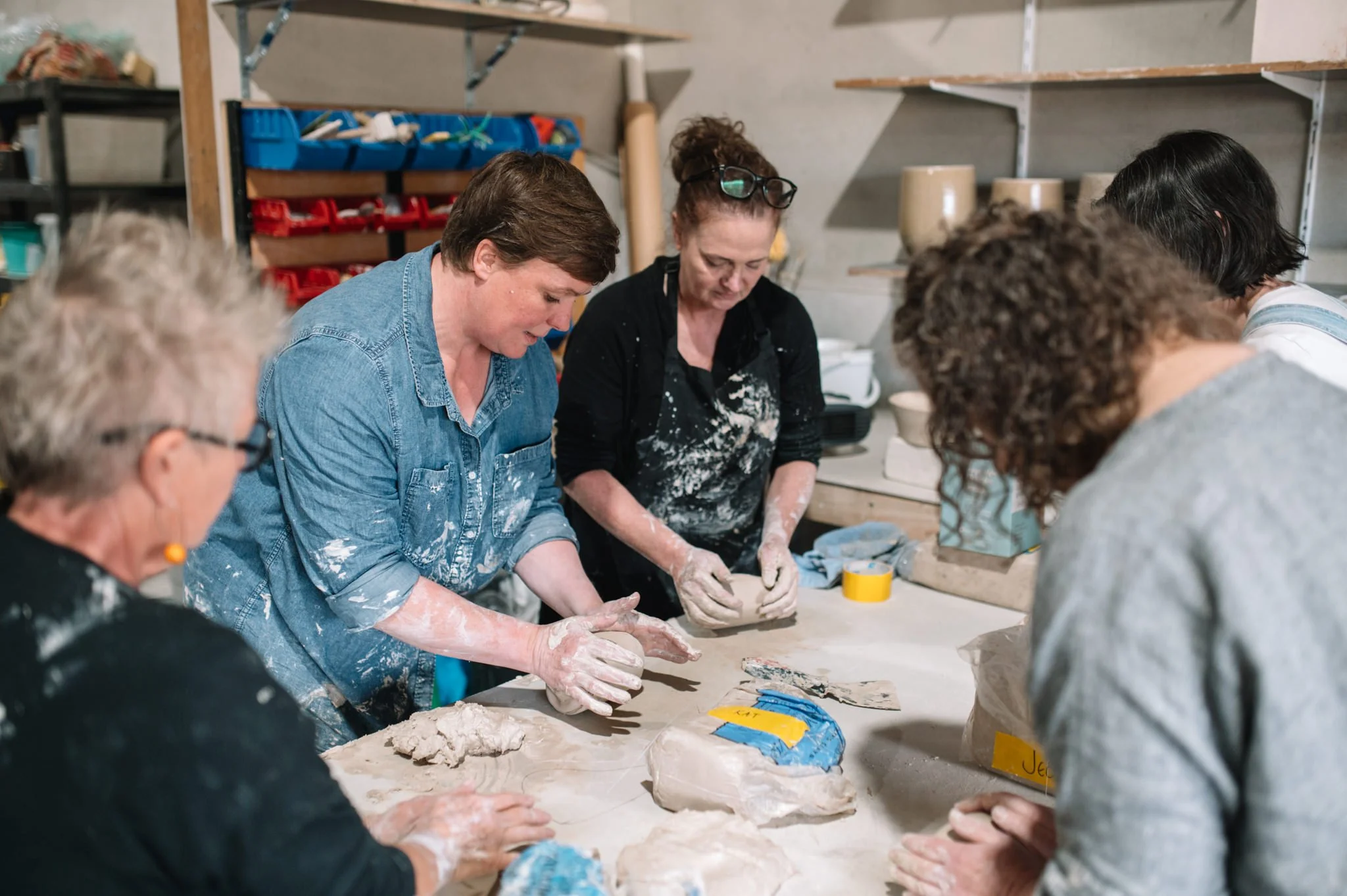 Group of students hand-building with clay in a relaxed pottery workshop near Hobart, Tasmania