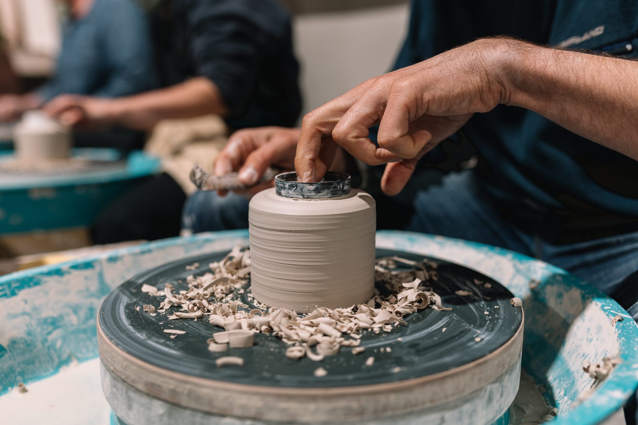 Detail of trimming a ceramic vessel on the wheel during a pottery class at Huon Valley Pottery