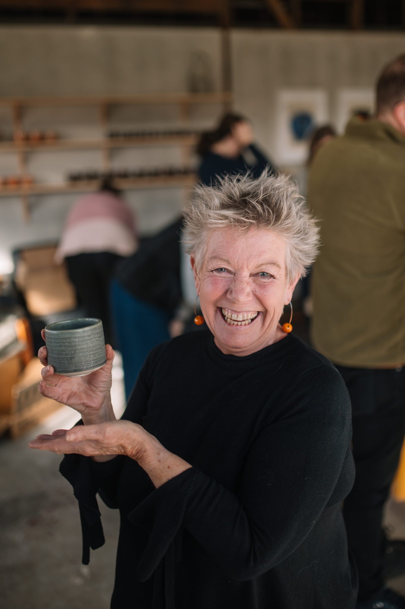 Student holding a handmade ceramic cup during a pottery class at Huon Valley Pottery in Tasmania
