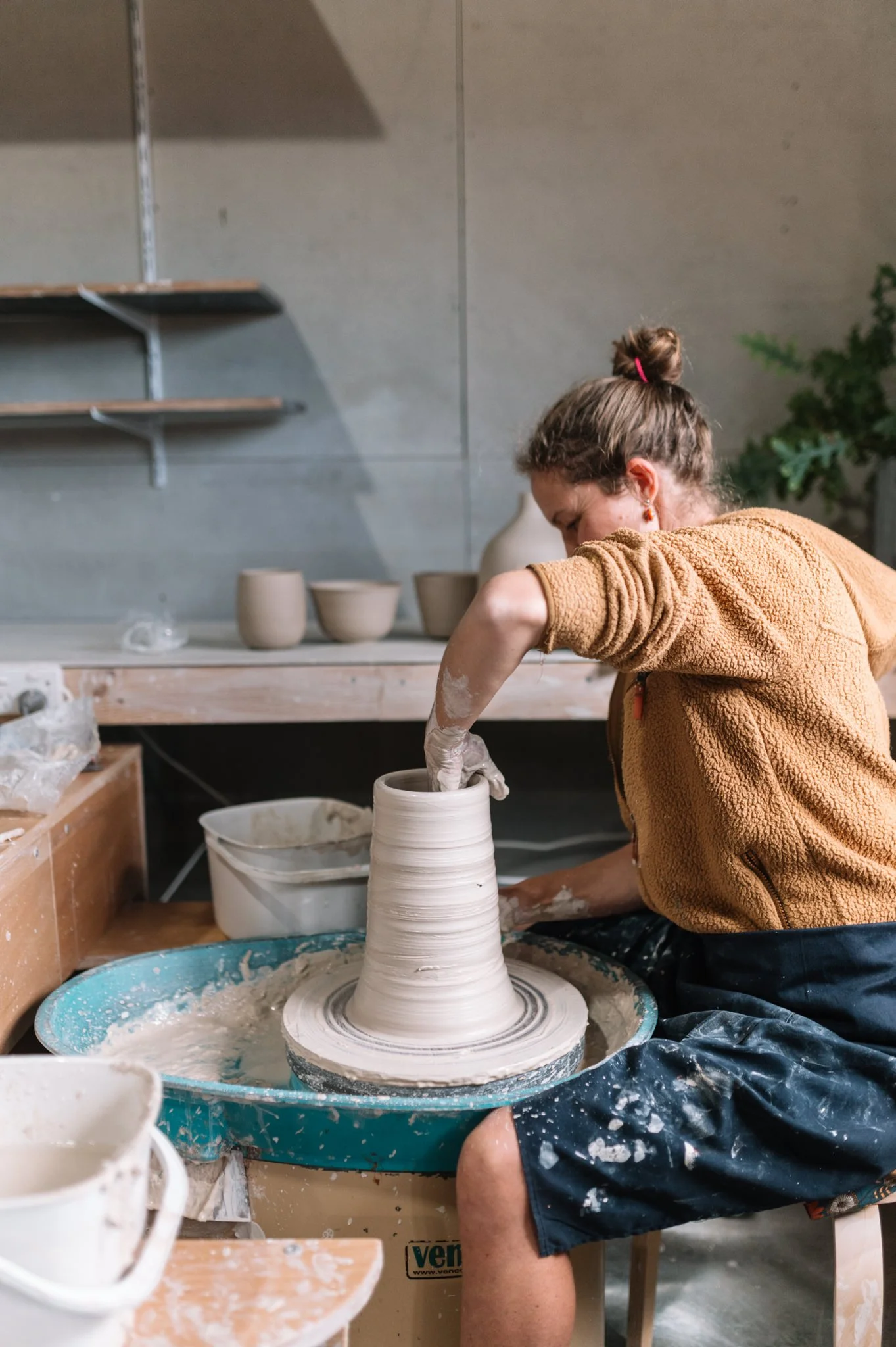 Student shaping clay on a pottery wheel during a studio membership session in Huonville, Tasmania