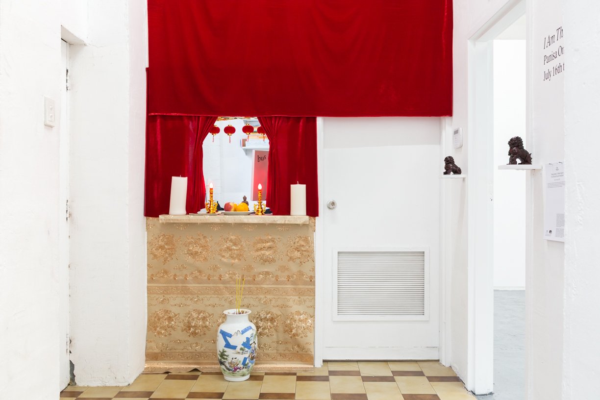  Theoretical Temple   
Melissa Nguyen and Panisa Ongwat. 
2025.  
Vinyl, cellophane, velour, LED candles, lanterns, electric candles, porcelain vase, painters tape, sand, Mansome bottle, incense, Buddha statues, monk statues, gong, concrete Yin Yang 
