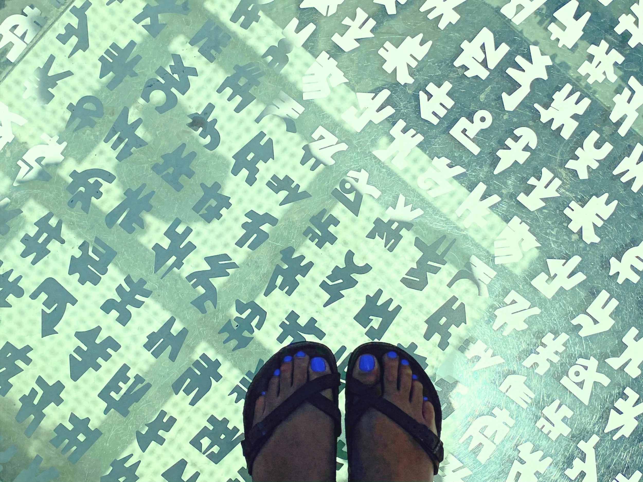 feet in sandles standing on a transparent floor with characters in solid color