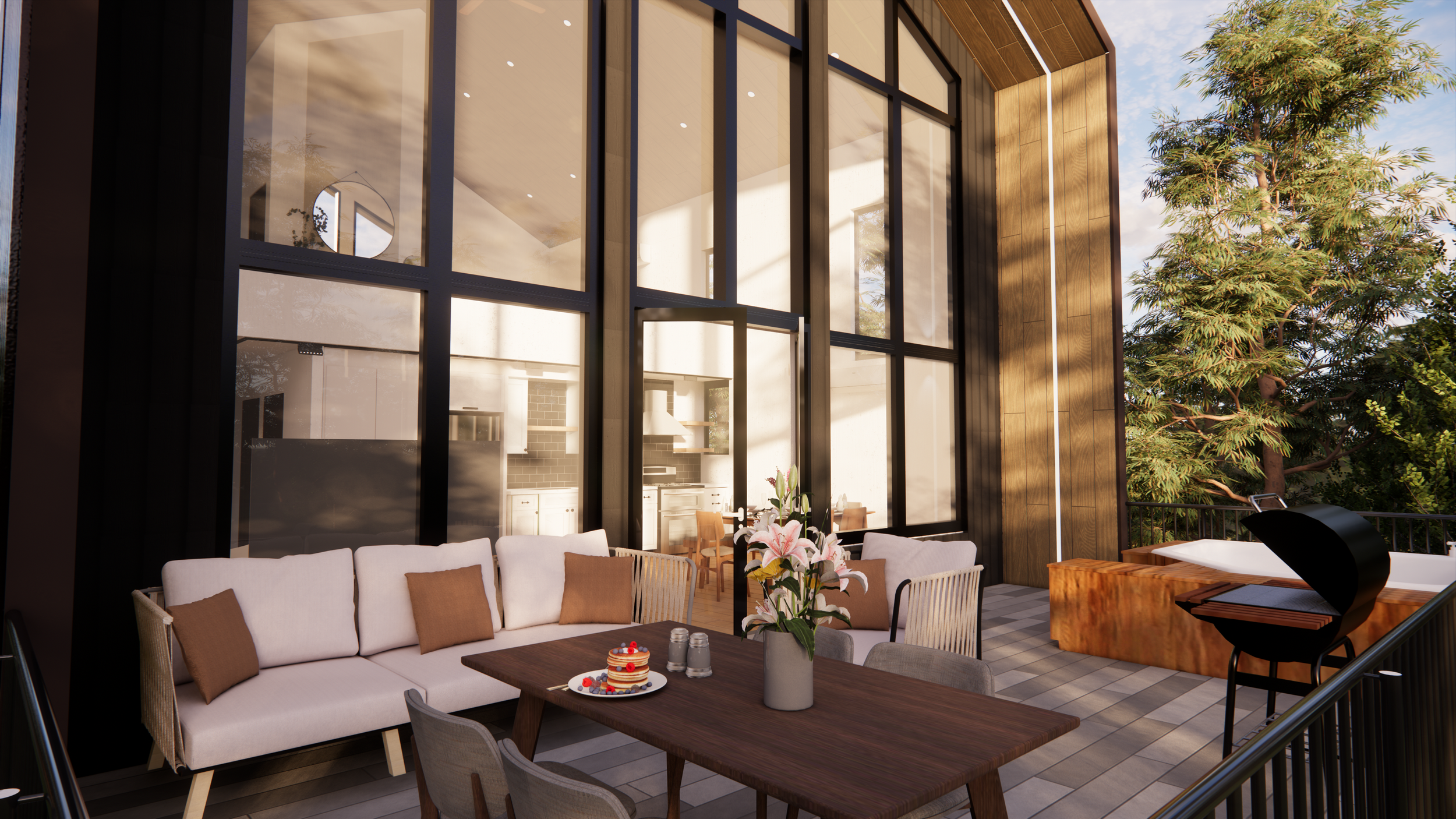 Modern outdoor patio with a wooden dining table, a pink floral centerpiece, a cake, and ice cream cups, white sofa with brown pillows, a hot tub, a grill, and trees, with a large glass wall and cozy indoor kitchen visible inside.