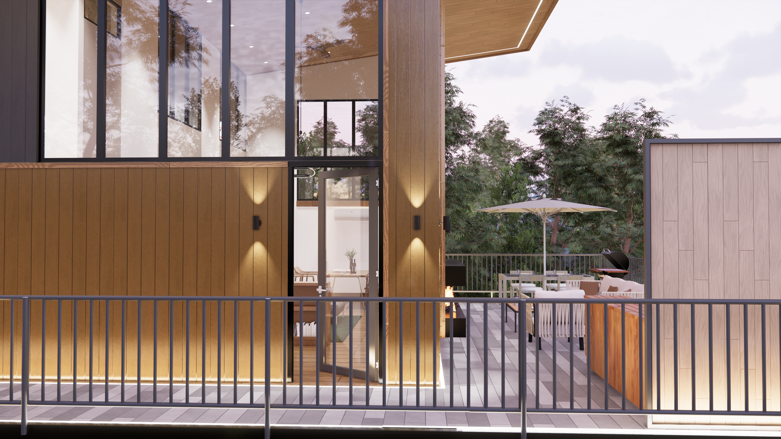 Modern residential building with large glass windows, wooden exterior panels, and an outdoor patio with seating, umbrellas, and trees in the background.