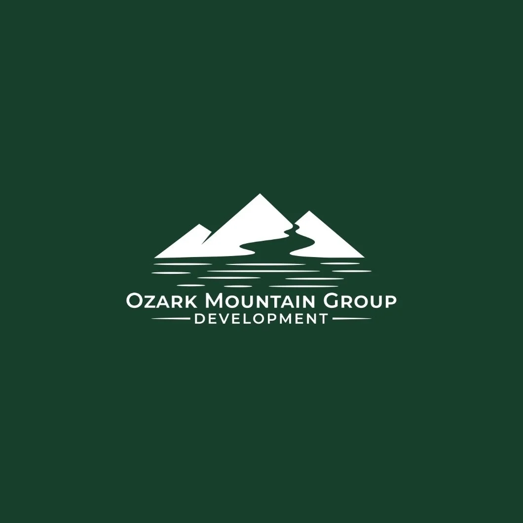 Logo of Ozark Mountain Group Development featuring a stylized mountain range with a river flowing through it on a green background.