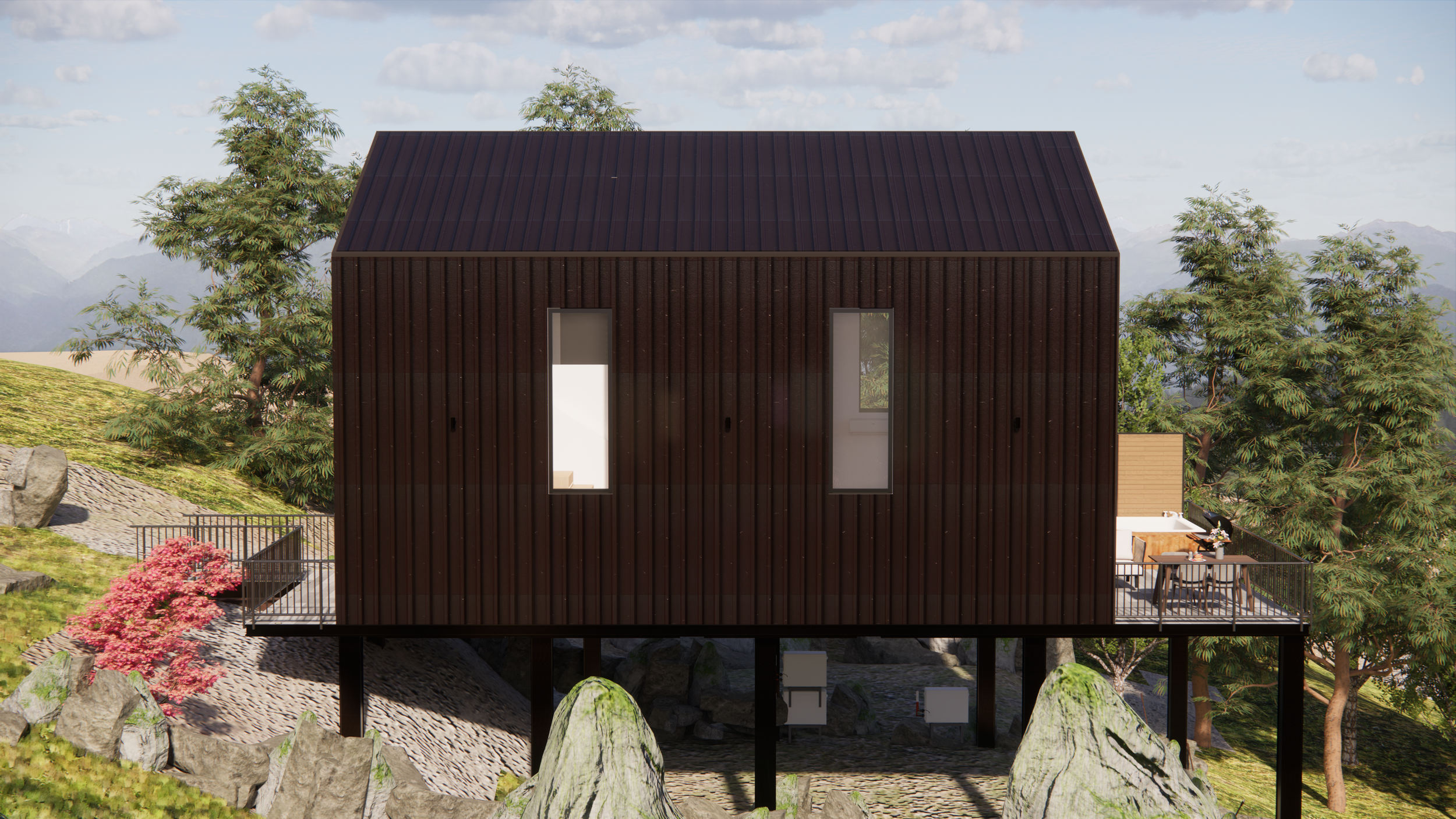 Modern elevated house with dark wood exterior, situated on a hillside with trees and rocks nearby, featuring a balcony with outdoor furniture and large vertical windows.
