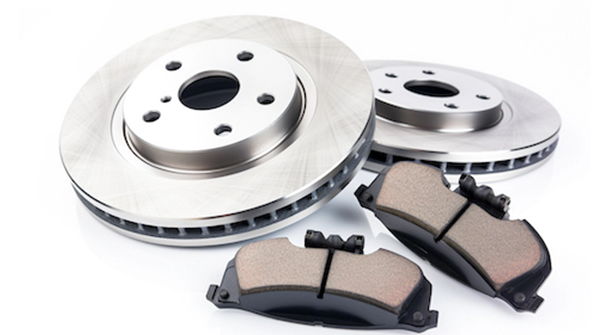 Two metallic brake rotors with black central holes and two brake pads with textured friction surfaces on a white background.
