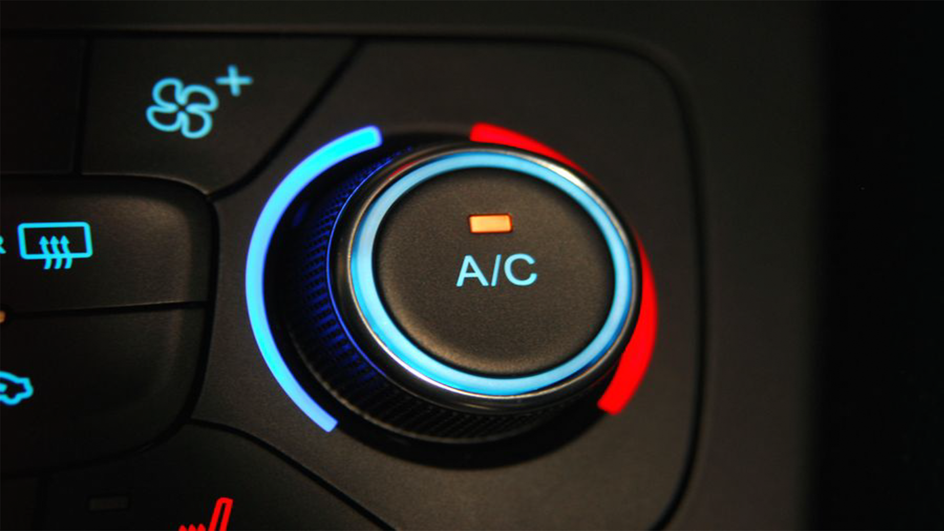 Car climate control panel with a circular dial set to air conditioning, showing a blue and red temperature indicator, and buttons for heated seats and defrost functions.