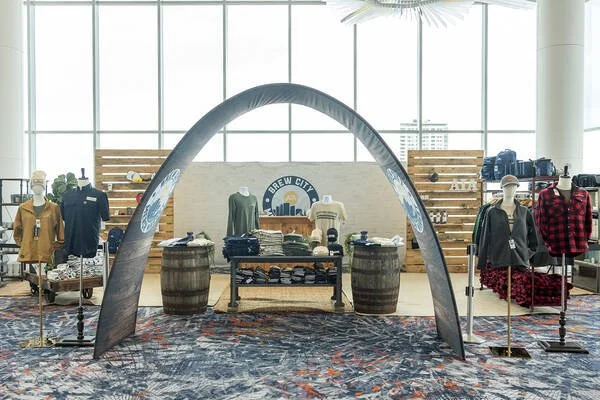 Arch that leads to a pop-up merch shop with apparel and hardgoods