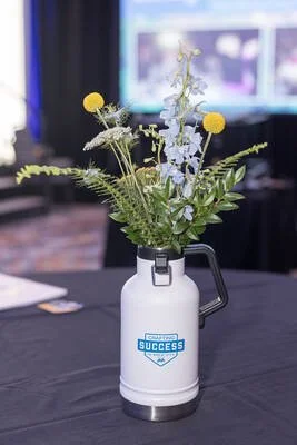 Beer Growler filled with flowers as a centerpiece on a table