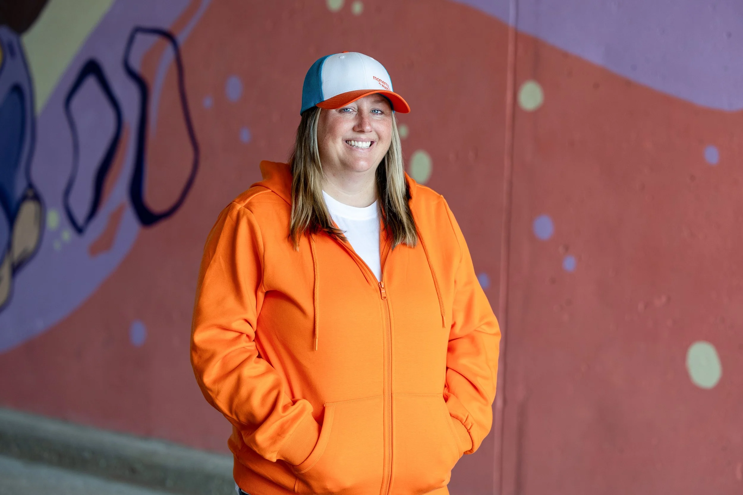 Girl in orange sweatshirt and hat