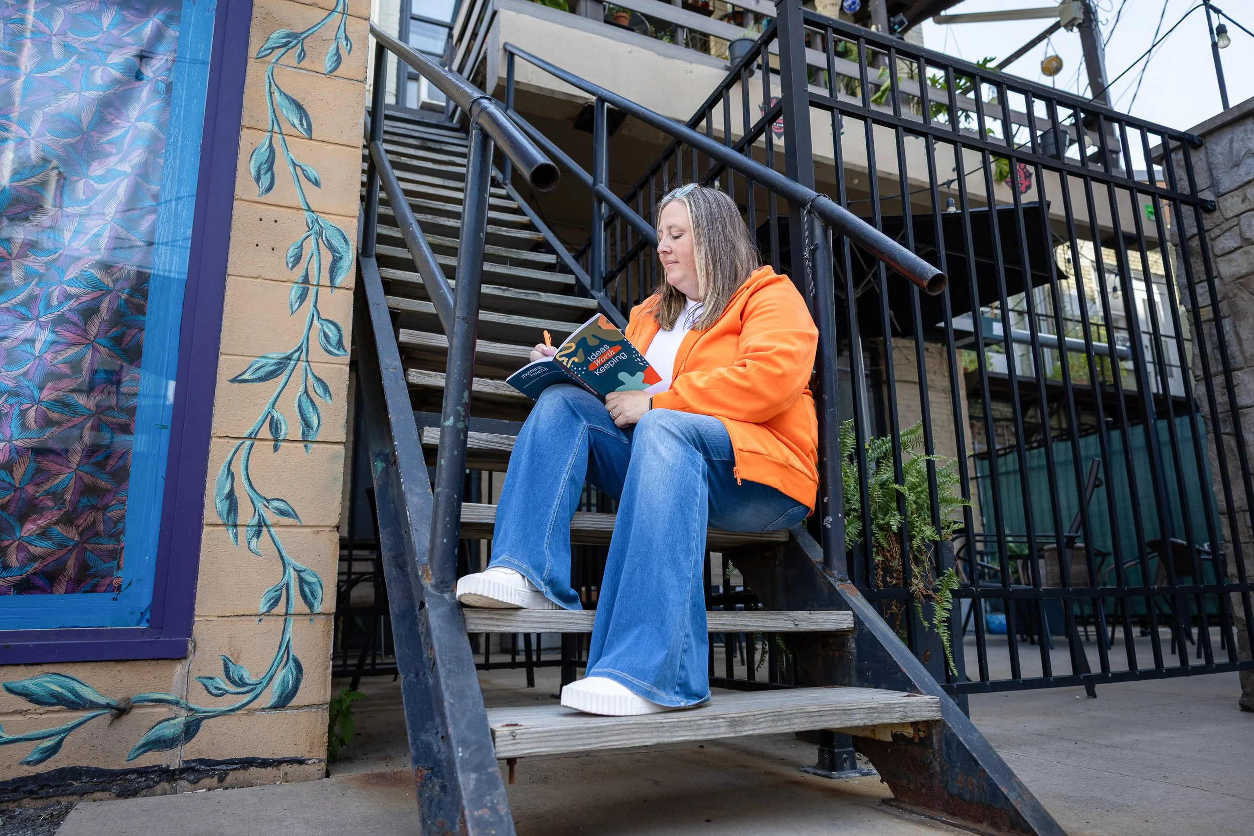 Girl on steps writing with notebook