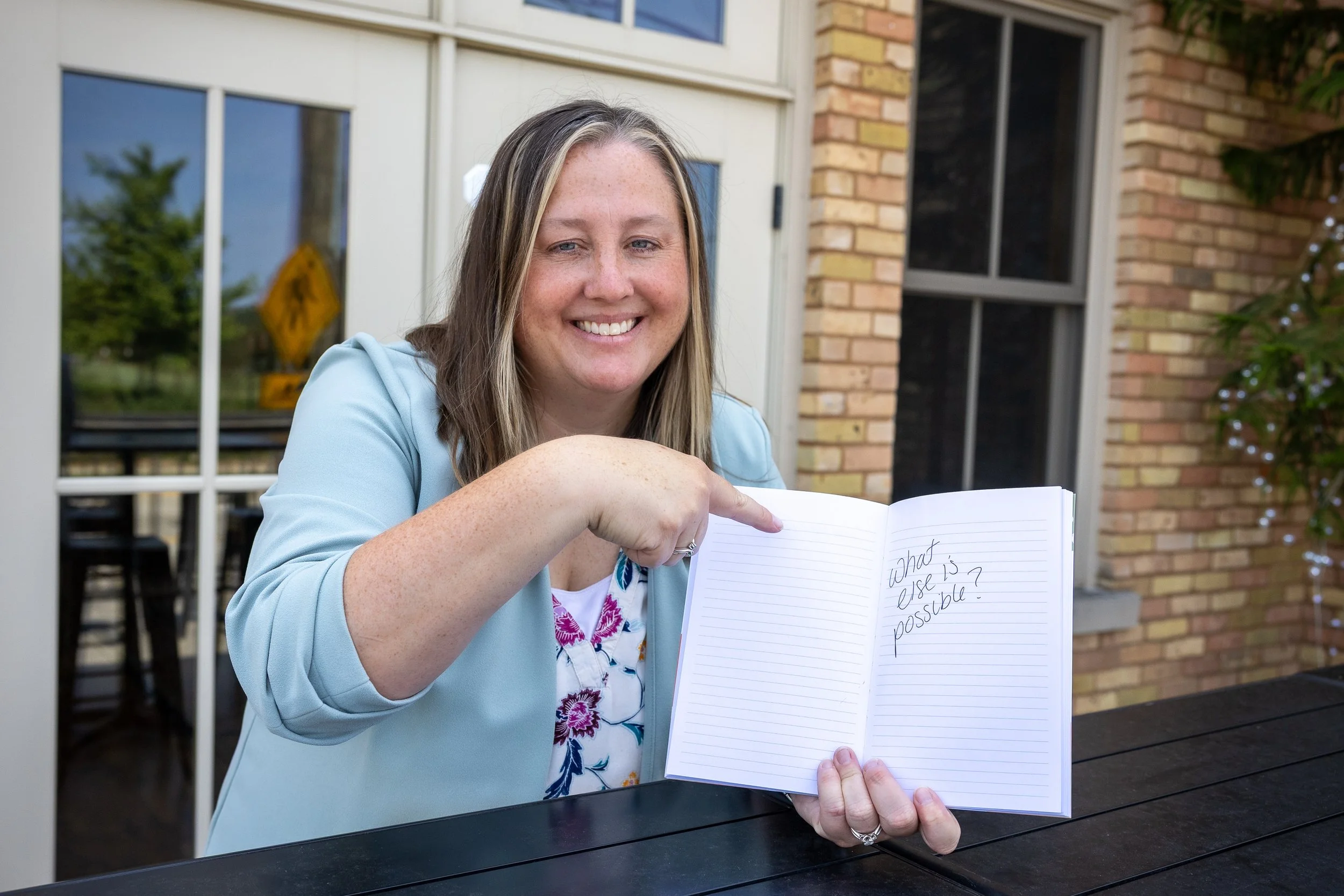 Woman pointing to what else is possible written in notebook.jpg