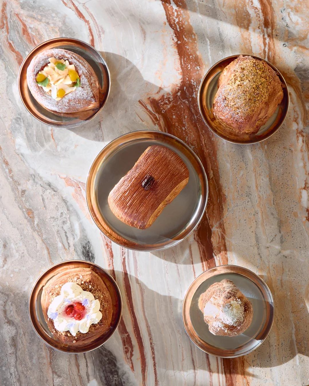 An overhead image of pastries on a marble table.