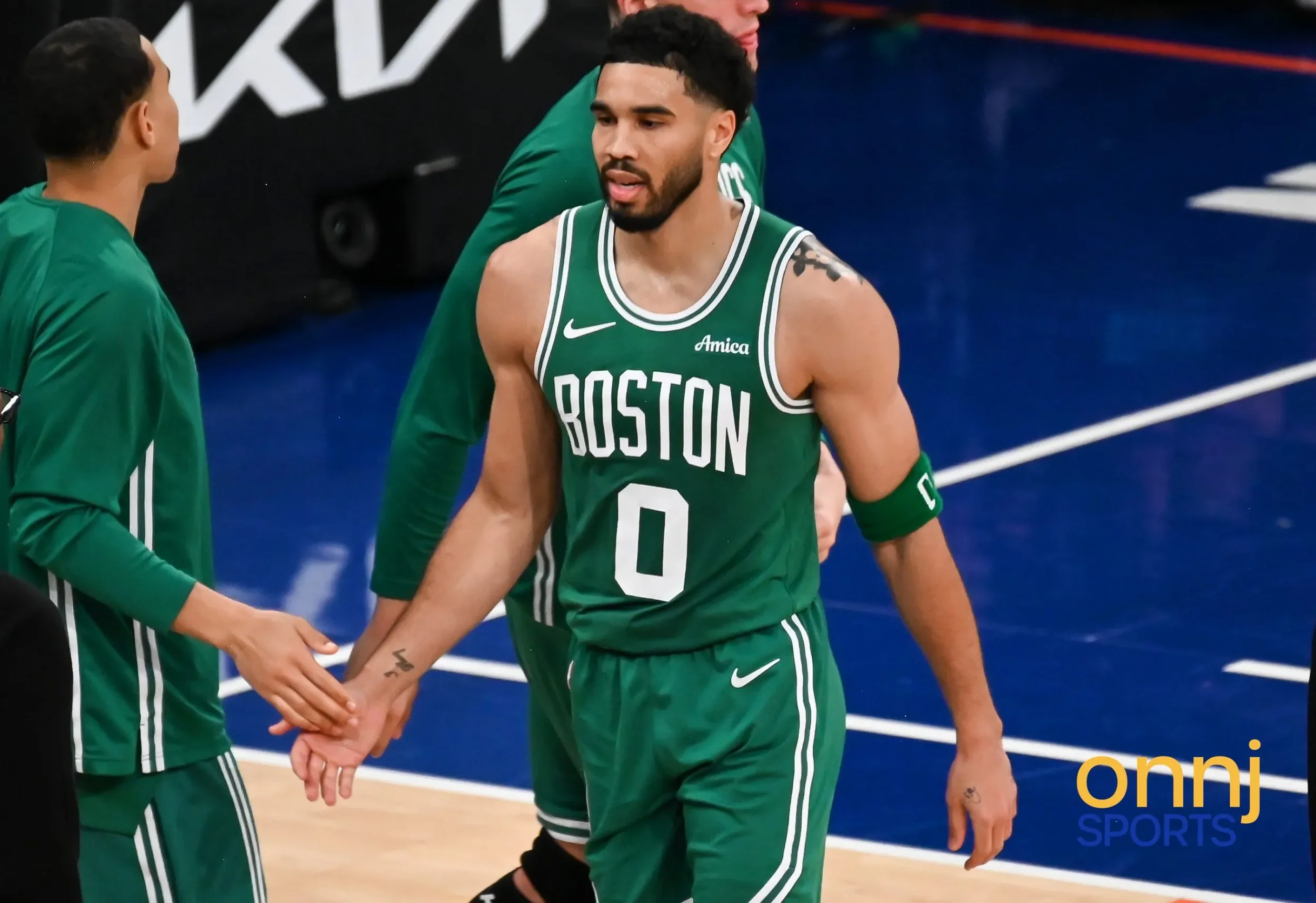 Jayson Tatum high fiving on the way to the bench