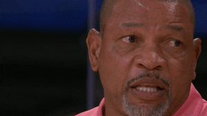 Doc Rivers side-eyeing and laughing GIF