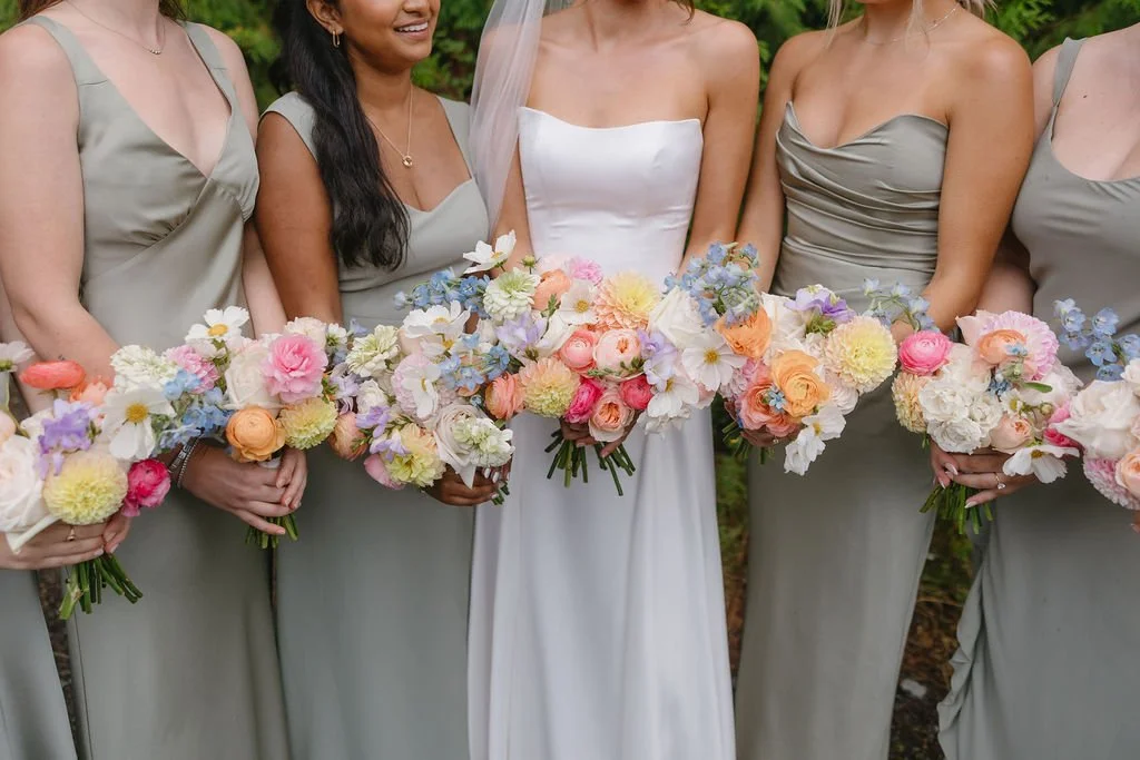 Bridal party holding bouquets of colorful flowers at a wedding.