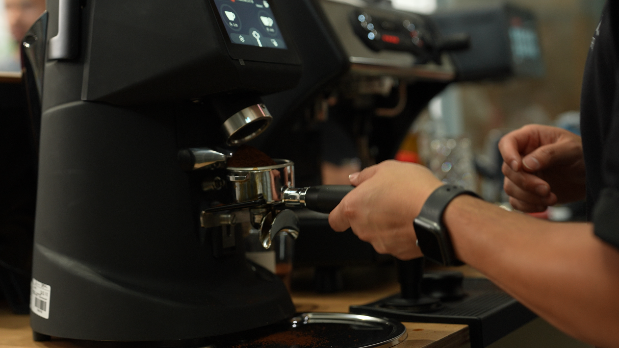 A person making espresso coffee using a professional espresso machine.