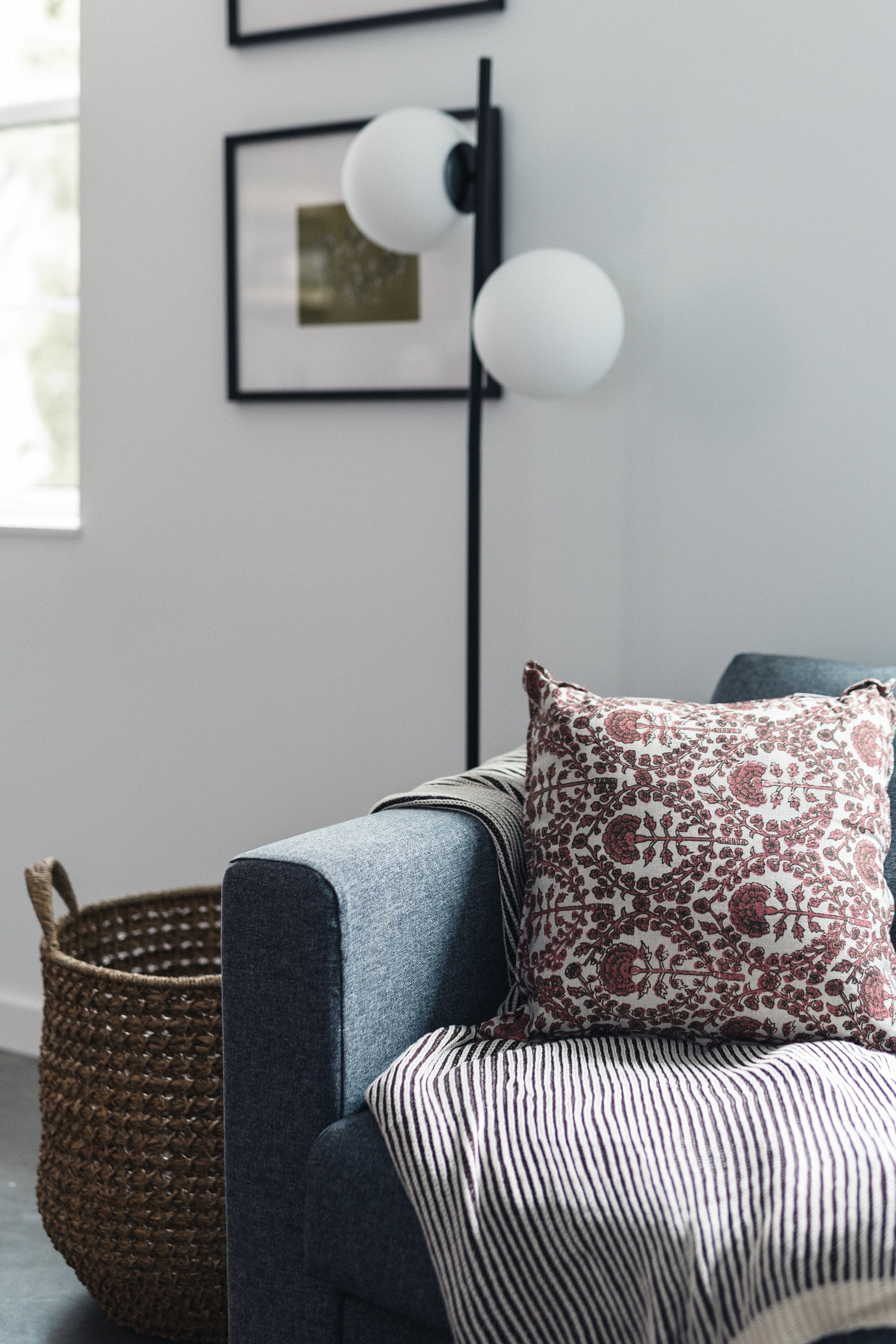 Living room corner with a blue upholstered sofa bed, a decorative pillows and throw blankets were thoughtfully chosen for your comfort during your stay in Kaslo, BC.