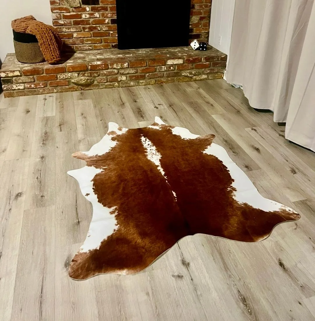 "The family room signature cowhide rug, paired with matching accent pillows, leaves no question that it's time to get cozy by the  fireplace with a blanket."