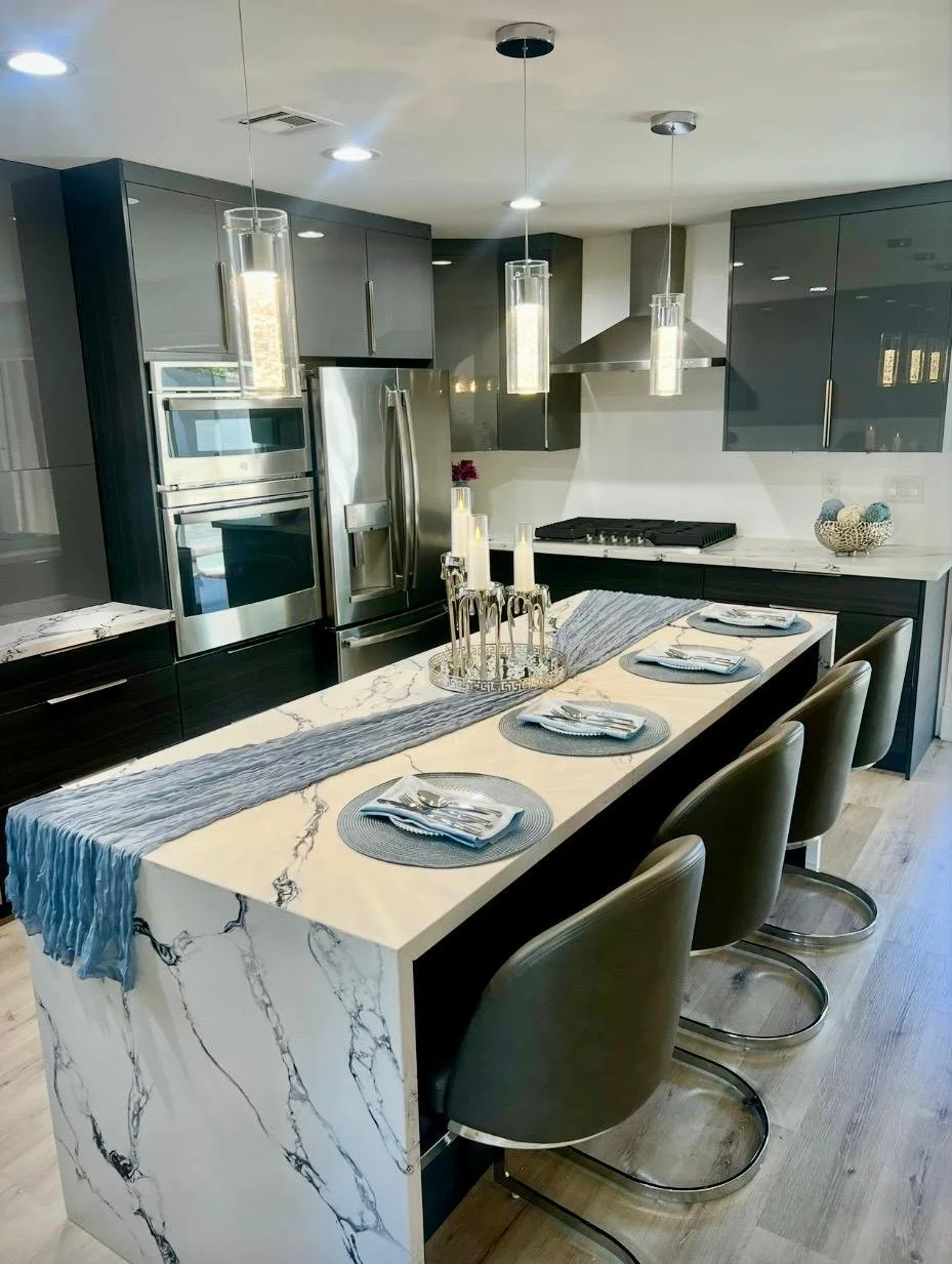 "Kitchen island designed as an elegant gathering space for conversation, breakfast, or entertaining guests with cocktails and hors d'oeuvres."