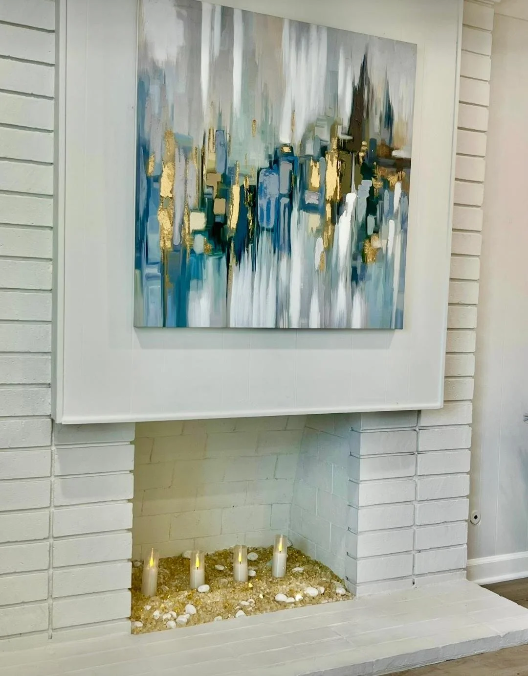 "The richly colored fireplace, paired with a bold art piece, serves as warm focal point.  Layered textures with decorative crystals and rock accents create a unforgettable statement piece."