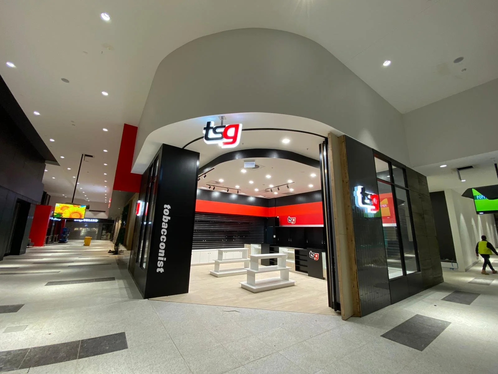 Empty storefront of TSG gaming store inside a mall with black and red decor.