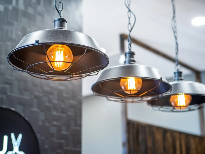Three vintage industrial pendant lights with exposed Edison bulbs hanging from chains.