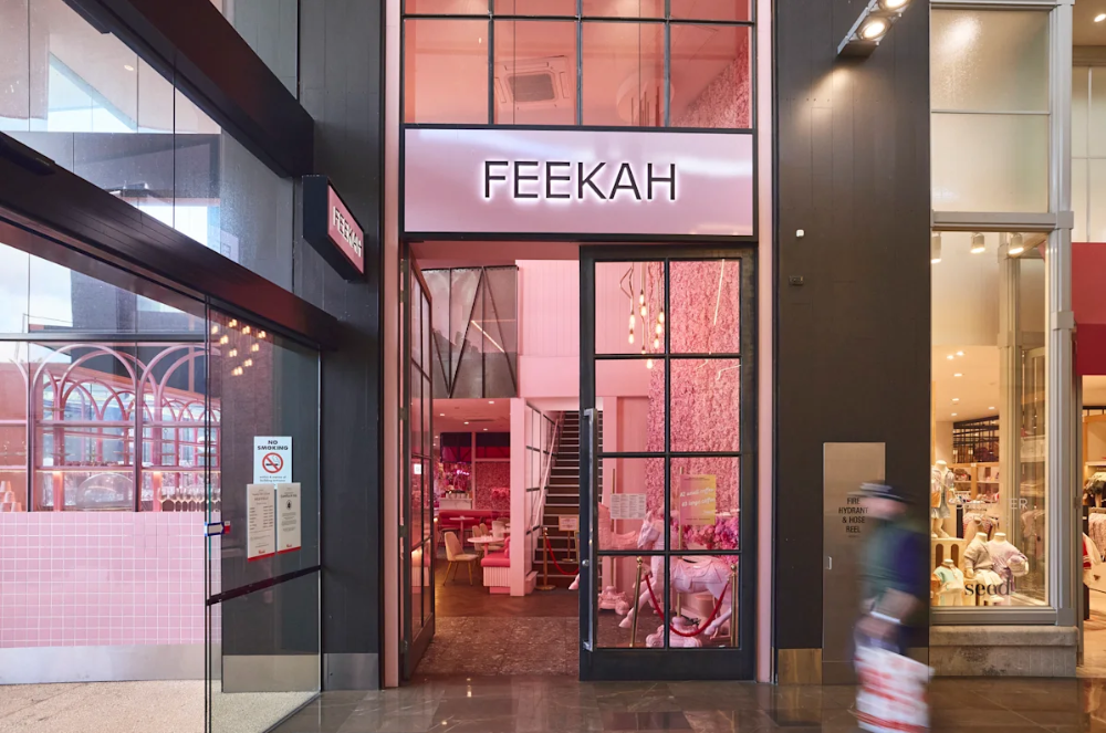 Storefront with a sign that reads 'FEKAH', dressed in black with pink accents visible inside.