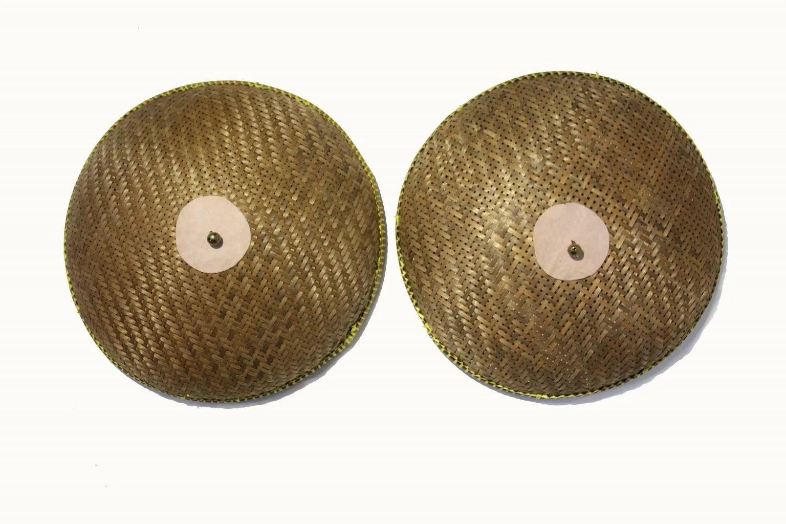 Two round woven bamboo fans with white paper centers and small black central pins, positioned side by side on a white background.