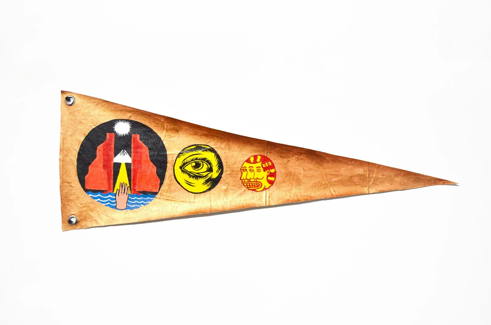 A triangular, tan-colored pennant with three colorful circular patches, pinned to a white background.
