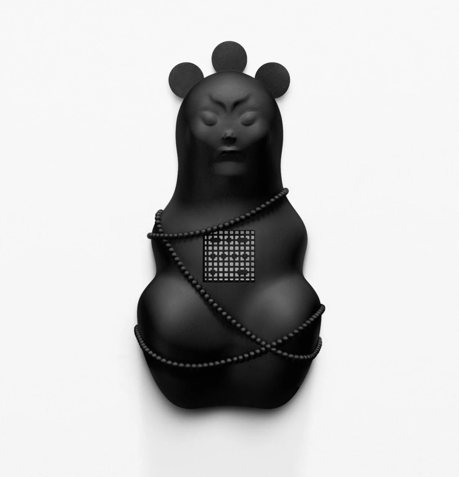 Black sculpture of a bear with closed eyes, wearing pearl necklaces and a geometric patterned square pendant, against a white background.