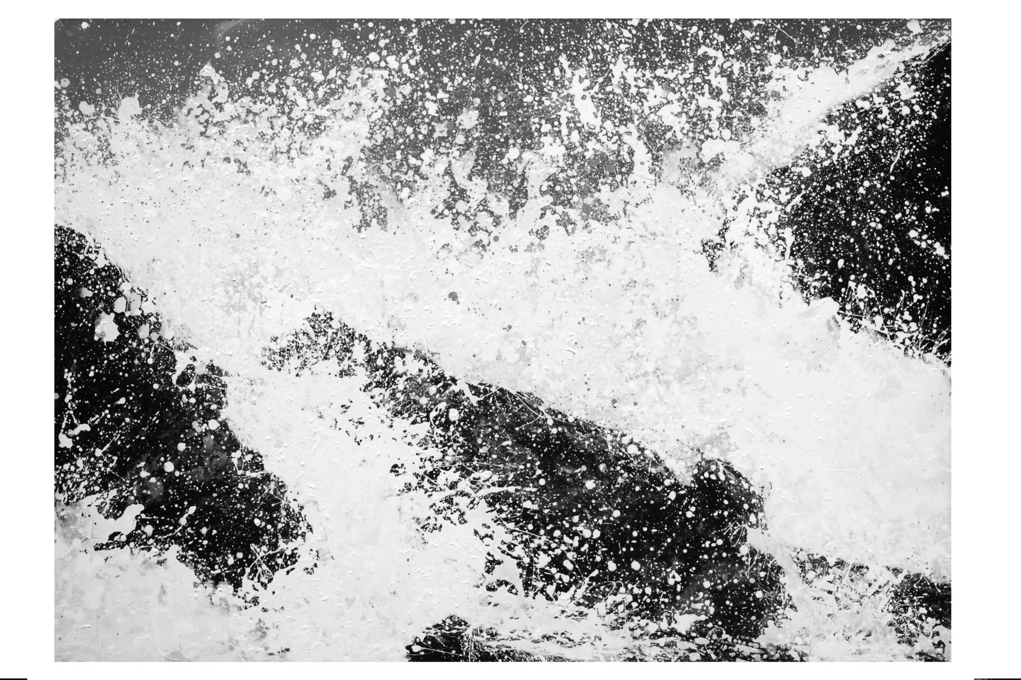 Abstract black and white splatter paint pattern with various splashes and drips across the surface.