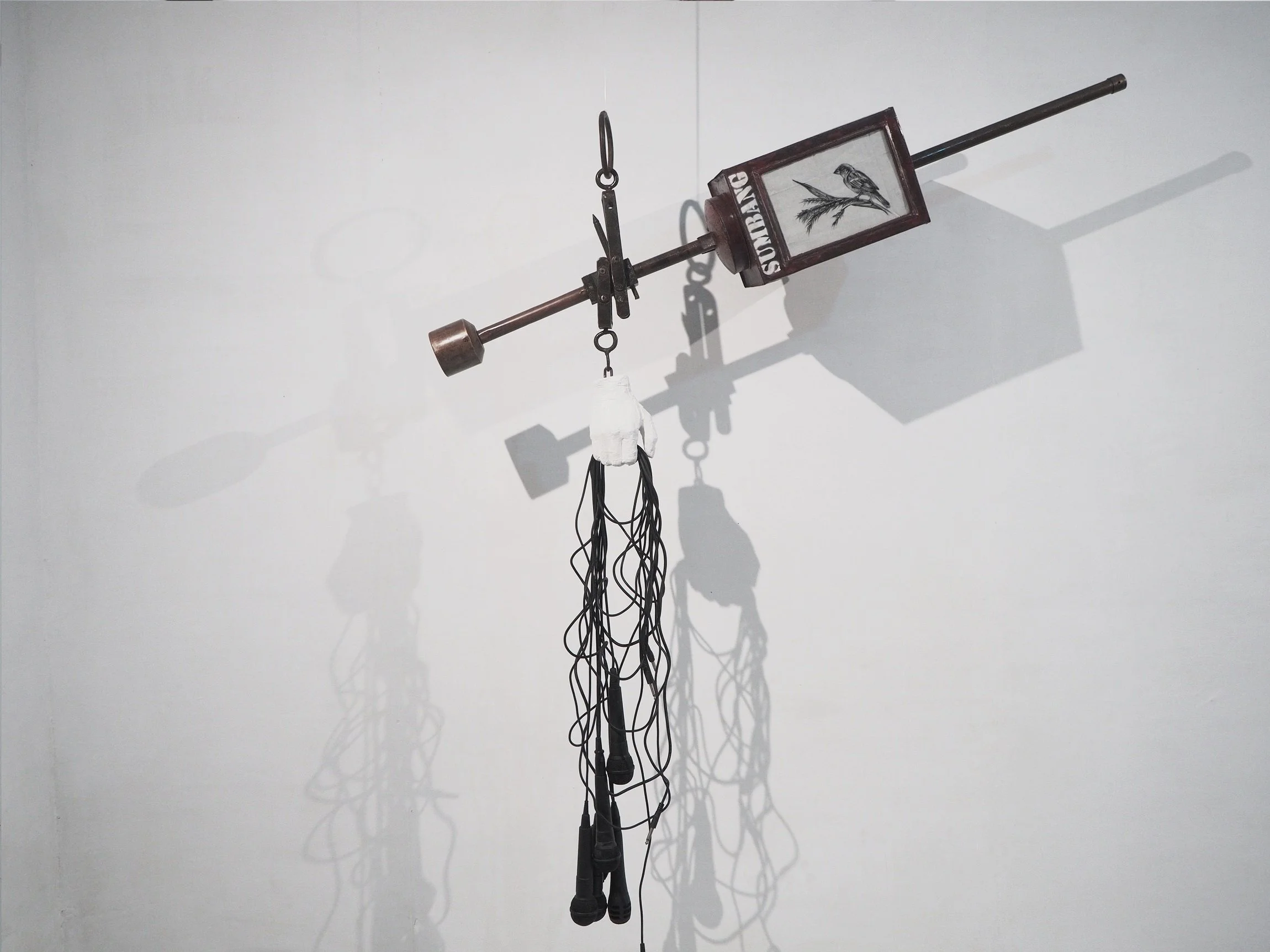  Moch Krismon Ariwijaya 
 Timbang Berimbang (Balanced Scale) 
 Microphones, wires, cracker box, canvas, scales, gypsum 
 180 cm x 80 cm x 200 cm, 2021 