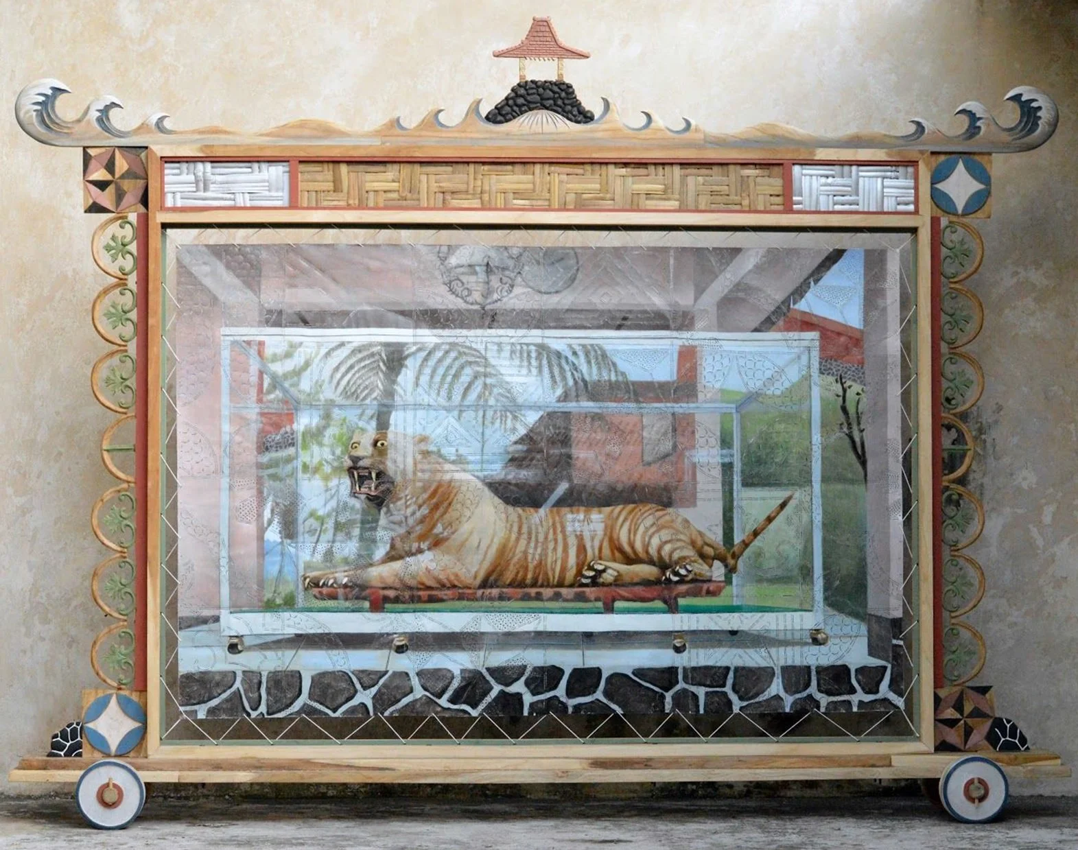 A decorative display case with a painted tiger inside a glass enclosure, featuring detailed colorful artwork of a tiger lying down.