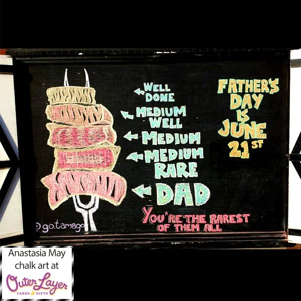 A BBQ fork shows 5 different cuts of steak with arrows pointing to ‘well done’, ‘medium well’, ‘medium’, ‘medium rare’, and rare is labelled ‘dad’. Under those labels it says ‘You’re the rarest of them all’. The art is inspired by a father’s day card