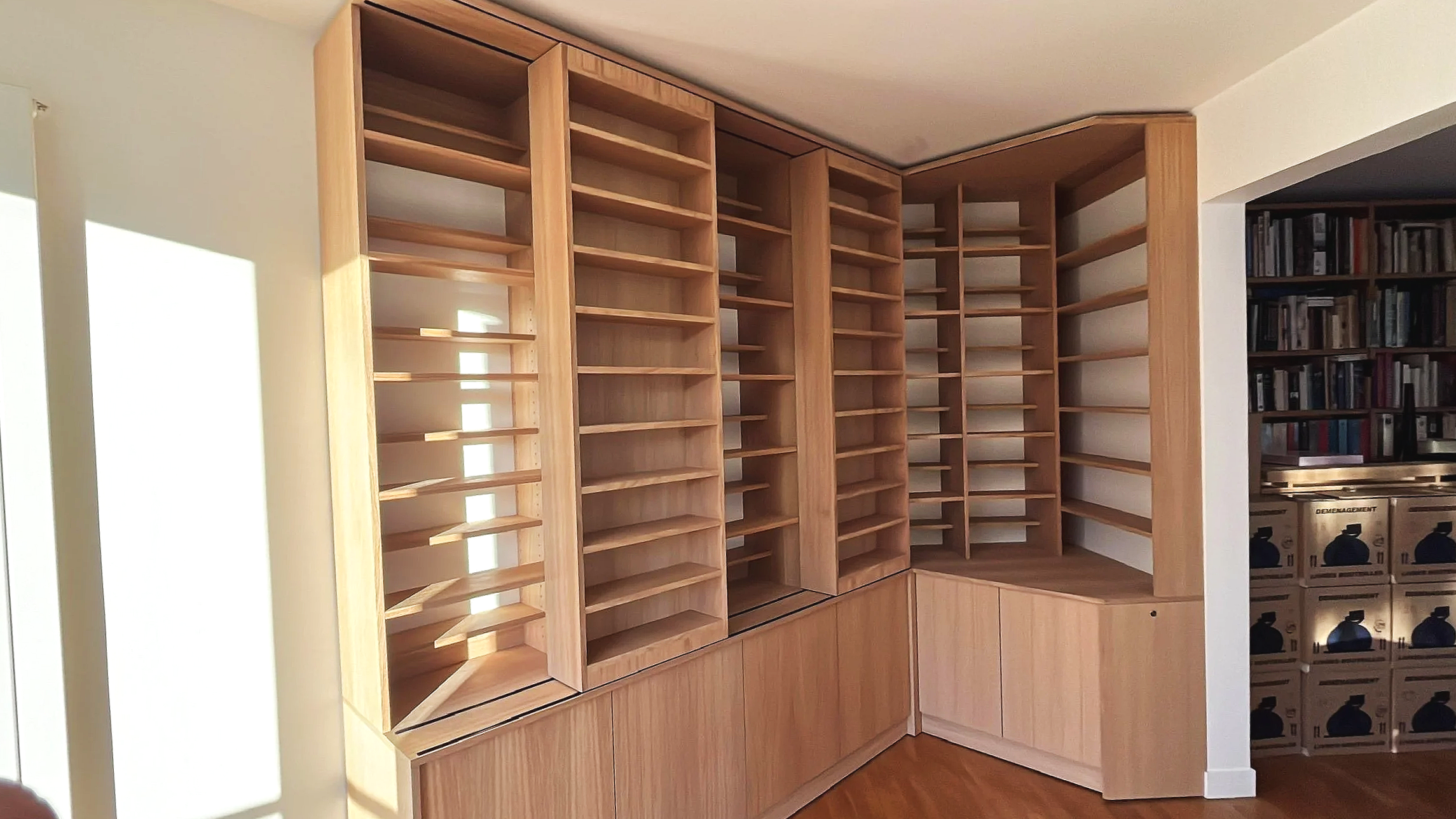 Étagères en bois remplies de livres, avec un éclairage au plafond