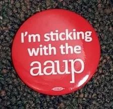 Red button with white text that reads, "I'm sticking with the aaup" on a dark textured surface.