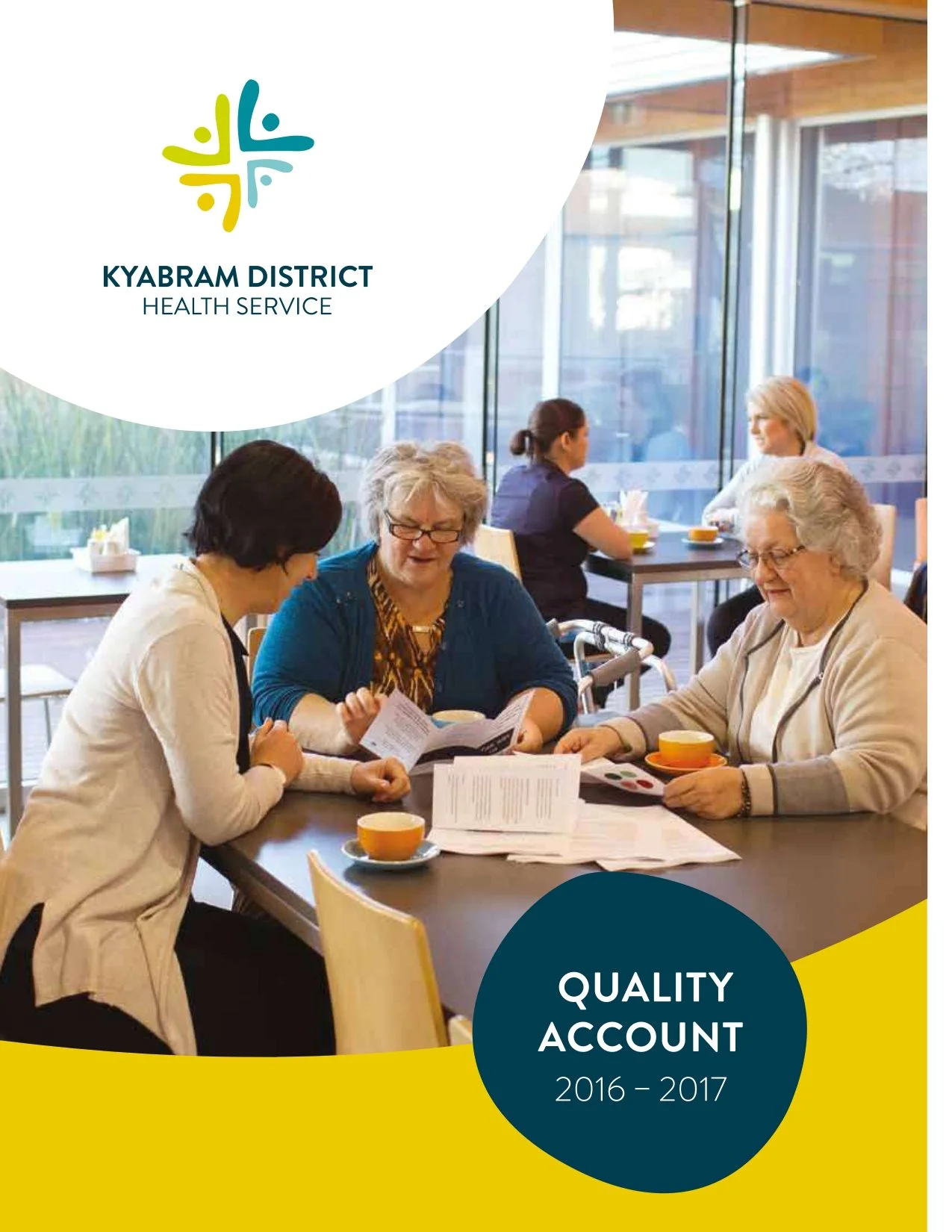 A group of healthcare professionals, including women of different ages, sitting at a table in a modern medical facility, discussing documents and looking at a presentation board. The setting is well-lit with large windows. The overlay text reads 'Kyabram District Health Service' and 'Quality Account 2016-2017'.